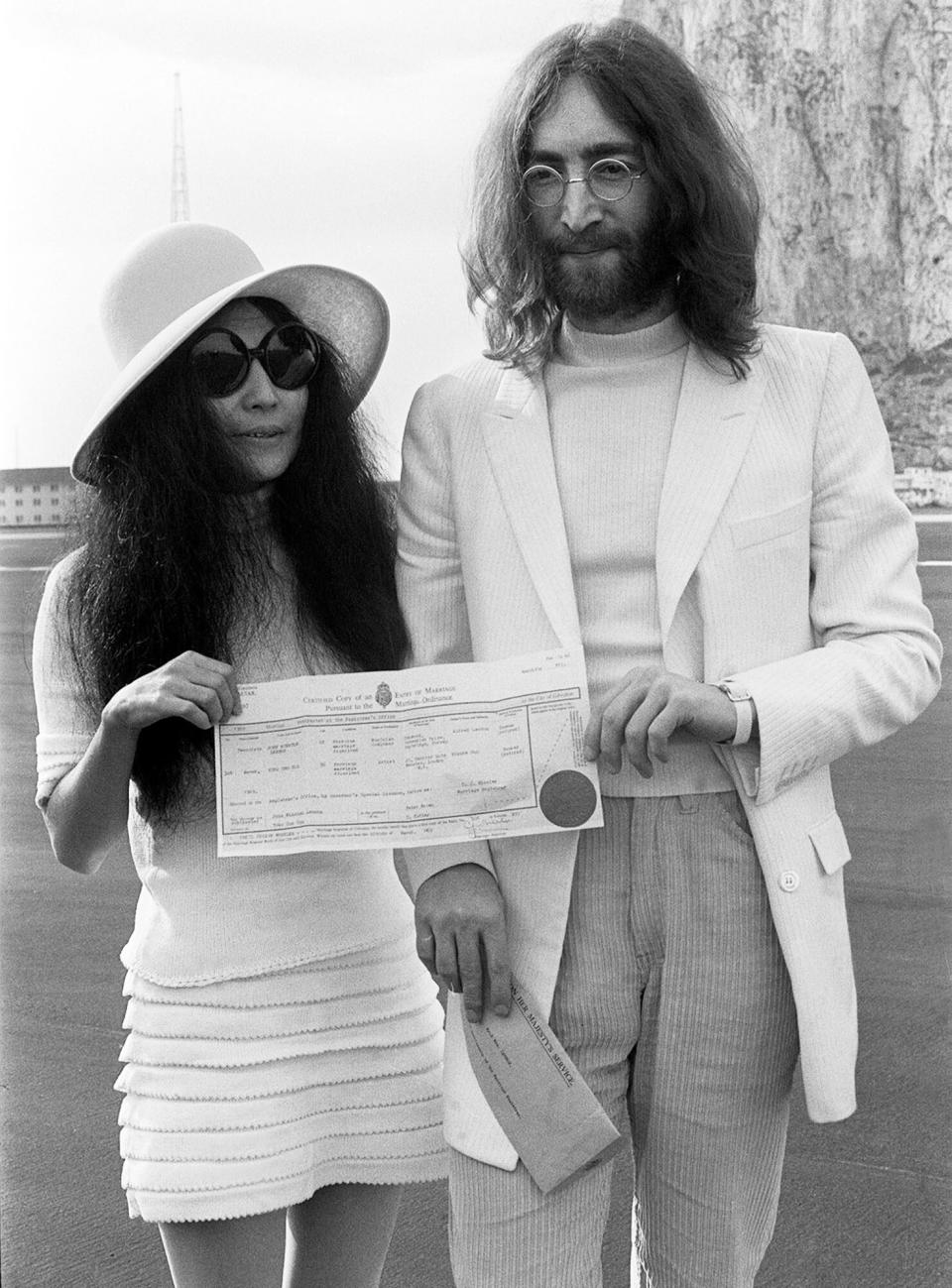 John Lennon and his new bride Yoko Ono holding their marriage certificate after their marriage in Gibraltar. 20 March 1969