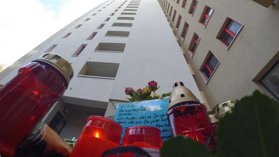 Von irgendwo da oben kam der Holzklotz: Blumen, Kerzen und Karten vor einem Hochhaus im Märkischen Viertel, wo ein acht Jahre alter Junge starb. Foto: Paul Zinken