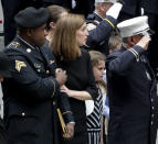 Shannon Slutman, second from left, holds onto a Marine officer as the casket for her husband, U.S. Marine Corps Staff Sergeant and FDNY Firefighter Christopher Slutman, arrives for his funeral service at St. Thomas Episcopal Church, Friday April 26, 2019, in New York. The father of three died April 8 near Bagram Airfield U.S military base in Afghanistan. (AP Photo/Bebeto Matthews)