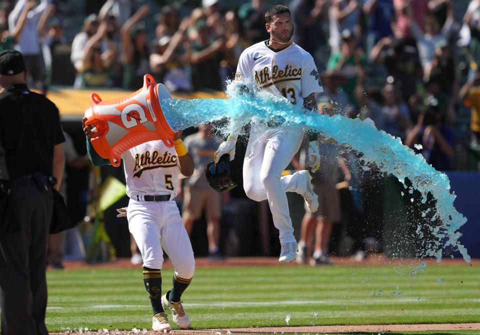 May 14, 2022; Oakland, California, USA; Oakland Athletics left fielder Luis Barrera (13) is doused with Gatorade by second baseman Tony Kemp (5) after hitting a home run against the Los Angeles Angels during the ninth inning at RingCentral Coliseum. Mandatory Credit: Darren Yamashita-USA TODAY Sports