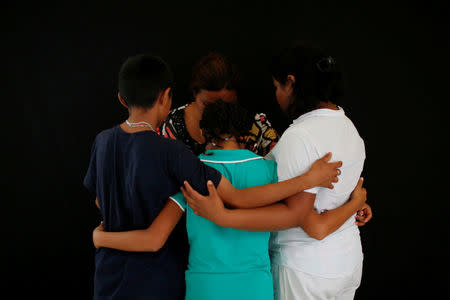 A woman from El Salvador, 40, who didn't want to be identified and who is hoping to get refugee status in Mexico, poses for a photograph with her children at a migrant shelter, known as The 72, in Tenosique, Tabasco, Mexico, April 12, 2017. "I left our home in El Salvador because of violence. I already lost one of my children in a shootout. I just want to live in peace with my children in Mexico or in the United States," she said. REUTERS/Carlos Jasso