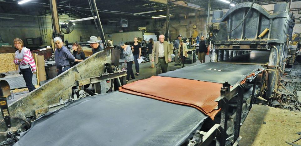 Visitors to the Ace Rubber factory look at a rubber press during a tour of historic buildings in Akron in 2016.
