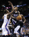 Sacramento Kings guard Isaiah Thomas (22) drives between Oklahoma City Thunder forward Serge Ibaka (9) and center Kendrick Perkins (5) in the second quarter of an NBA basketball game in Oklahoma City, Sunday, Jan. 19, 2014. (AP Photo/Sue Ogrocki)