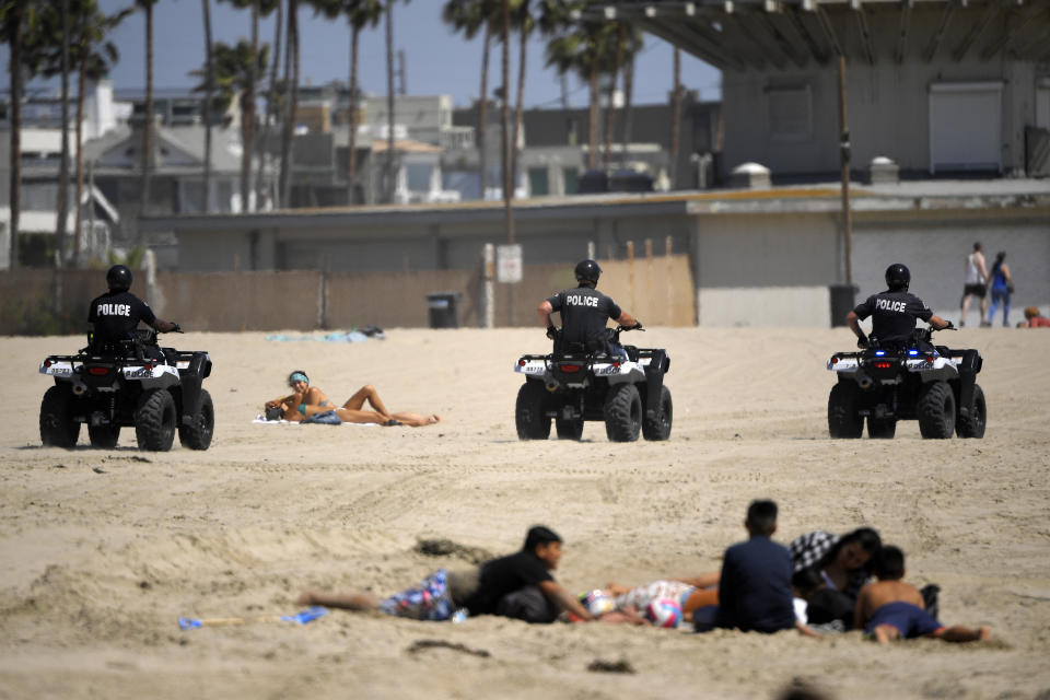 FILE - In this May 13, 2020 file photo, Los Angeles police officers patrol Venice Beach during the coronavirus outbreak in Los Angeles. In state after state, the local health departments charged with doing the detective work of running down the contacts of coronavirus patients are falling well short of the number of people needed to do the job. (AP Photo/Mark J. Terrill, File)