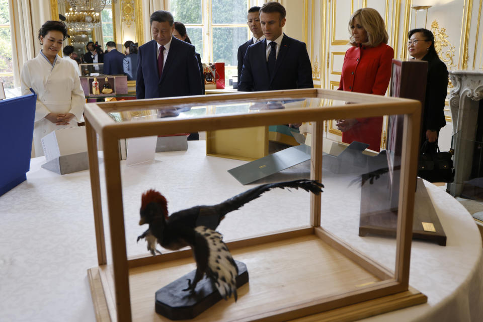 Chinese President Xi Jinping, second left, presents to French President Emmanuel Macron gifts laid out on the table, as their wives China's Peng Liyuan, left, and the French President's wife Brigitte Macron look on during a gifts exchange at the Elysee Palace in Paris, Monday, May 6, 2024. China's President Xi Jinping is in France for a two-day state visit that is expected to focus both on trade disputes and diplomatic efforts to convince Beijing to use its influence to move Russia toward ending the war in Ukraine. (Ludovic Marin, Pool via AP)