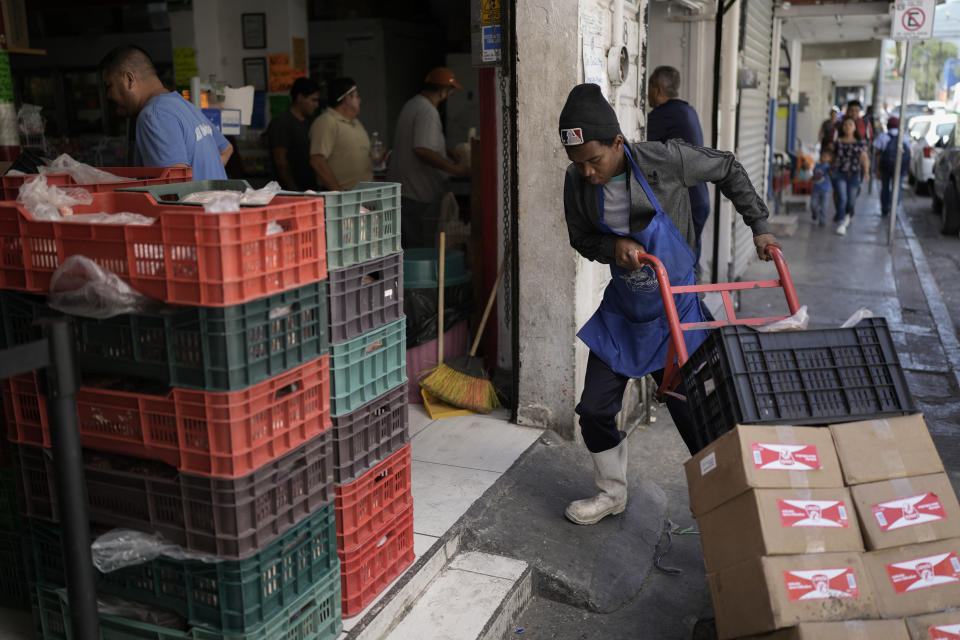 A Haitian migrant worker stacks boxes at a store near a market in Monterrey, Mexico, Thursday, April 11, 2024. Haitian and Central American migrants are transforming this prosperous industrial city, but the new arrivals aren't part of Mexico's political conversation as the country gears up for its presidential vote on June 2. (AP Photo/Eduardo Verdugo)