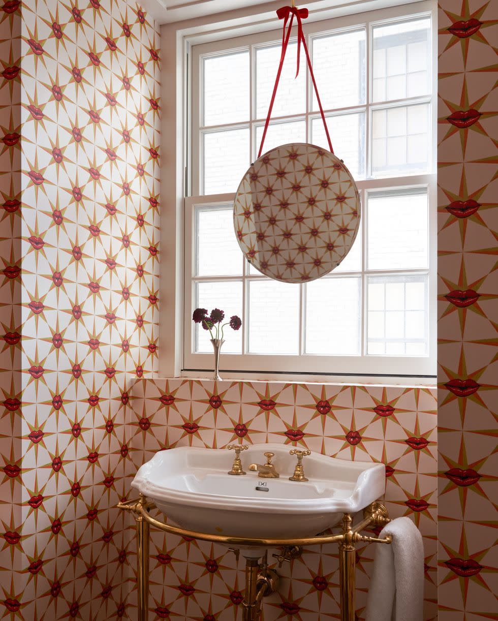 a bathroom with a red and white wallpaper