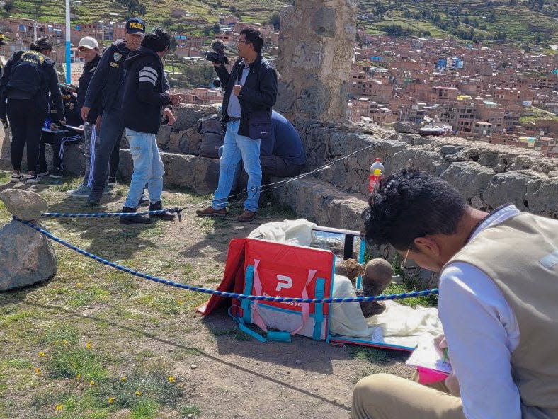 This handout picture released on February 25, 2023 by Puno TV shows members of the Decentralized Directorate of Culture of Puno and the police investigating the founding of a mummy inside a cooler box used by a delivery service worker in Puno, Peru.