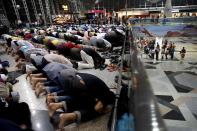 Muslim men offer prayers at the Kuala Lumpur International Airport for the missing Malaysia Airlines jetliner MH370, while on a level down, travellers queue up at immigration checkpoints, Thursday, March 13, 2014 in Sepang, Malaysia. Planes sent Thursday to check the spot where Chinese satellite images showed possible debris from the missing Malaysian jetliner found nothing, Malaysia's civil aviation chief said, deflating the latest lead in the six-day hunt. The hunt for the missing Malaysia Airlines flight 370 has been punctuated by false leads since it disappeared with 239 people aboard about an hour after leaving Kuala Lumpur for Beijing early Saturday. (AP Photo/Wong Maye-E)