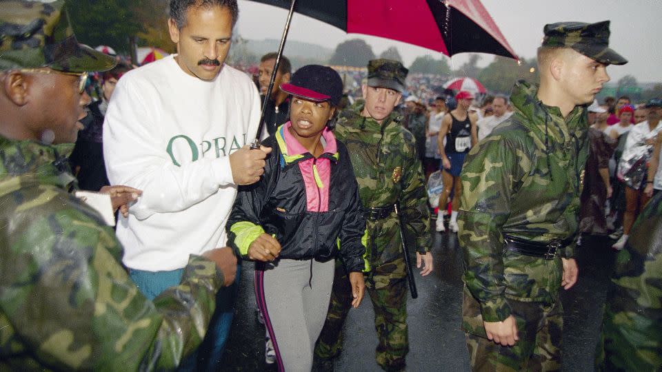 US Marine Corps personnel escort Oprah Winfrey and her partner Stedman Graham to the starting line of the 19th Marine Corps Marathon on October 23, 1994. - Mark Wilson/AP