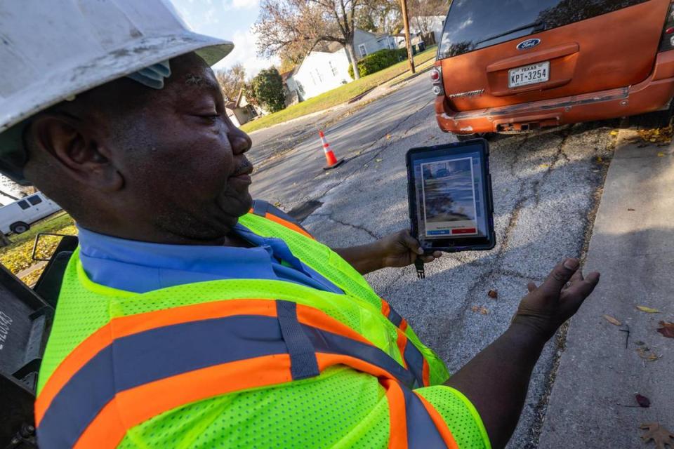 Pothole crew member Vernon Sawyer shows the tablet in which they get the address and location in the street where a pothole is located so they can find and fill it.