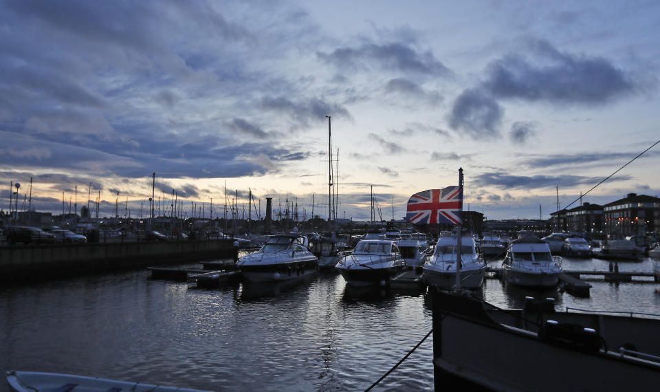 A British Union flag flutters in the breeze boats line the Marina in Hartlepool, England, Monday, Nov. 11, 2019. Political parties in Britain's Brexit-dominated December election are battling to win working-class former industrial towns, where voters could hold the key to the prime minister's office. The English port town of Hartlepool is an example. People there have long felt ignored by politicians in far-off London. (AP Photo/Frank Augstein)