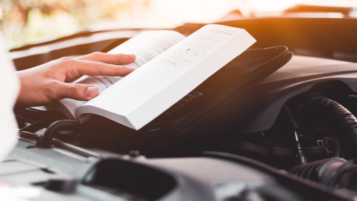 person reading car owners manual