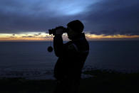 FILE - In this file photo dated Friday, Jan. 18, 2019, a French gendarme patrols the beach in Ambleteuse near Calais, northern France. Fifteen migrants have been saved Tuesday Oct. 27, 2020, and rescue and search operations are still under way, but at least four migrants, including a 5-year-old and 8-year-old child, have died Tuesday when their boat capsized while they and other migrants tried to cross the English Channel to Britain, French authorities said. (AP Photo Michel Spingler, FILE)