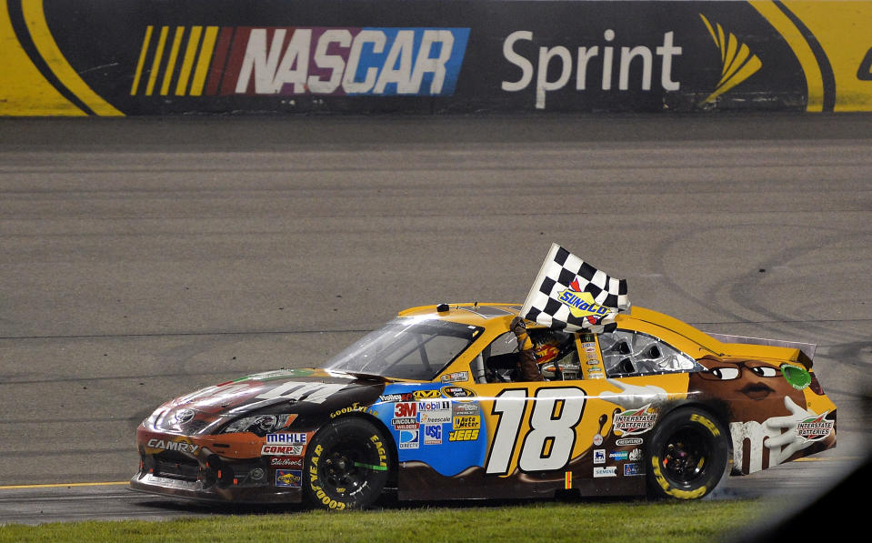 RICHMOND, VA - APRIL 28: Kyle Busch, driver of the #18 M&M's Ms. Brown Toyota, celebrates with the checkered flag after winning the NASCAR Sprint Cup Series Capital City 400 at Richmond International Raceway on April 28, 2012 in Richmond, Virginia. (Photo by Drew Hallowell/Getty Images)