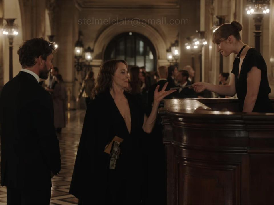 sylvie taking a ticket from an employee at the opera on emily in paris season three episode nine