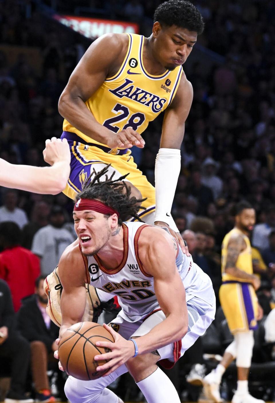 Lakers forward Rui Hachimura, top, lands on the back of Nuggets forward Aaron Gordon.