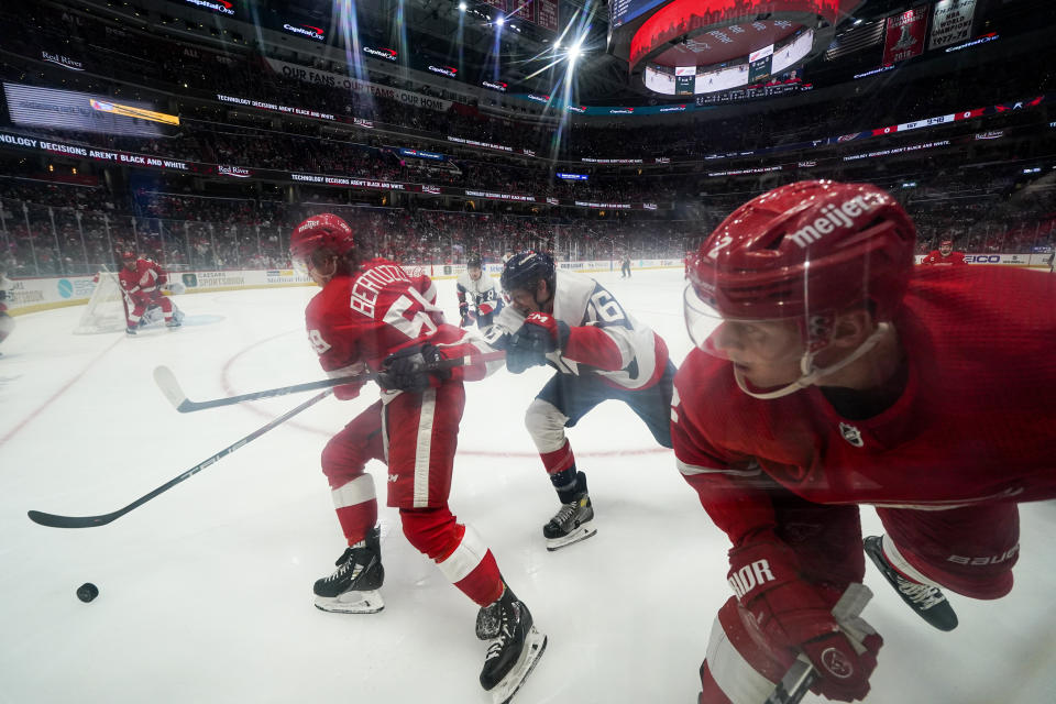 Detroit Red Wings left wing Tyler Bertuzzi, left, skates with the puck as Washington Capitals center Nic Dowd, center, and Red Wings' Olli Maatta, right, look on during the first period of an NHL hockey game, Tuesday, Feb. 21, 2023, in Washington. The Red Wings won 3-1. (AP Photo/Julio Cortez)