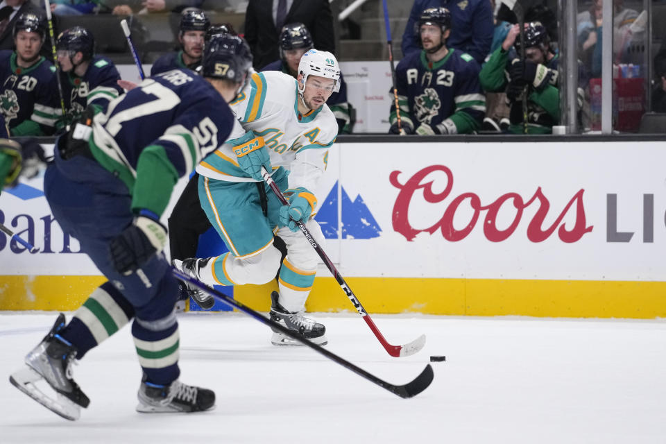 San Jose Sharks center Tomas Hertl (48) looks to pass while defended by Vancouver Canucks defenseman Tyler Myers (57) during the first period of an NHL hockey game in San Jose, Calif., Wednesday, Dec. 7, 2022. (AP Photo/Godofredo A. Vásquez)