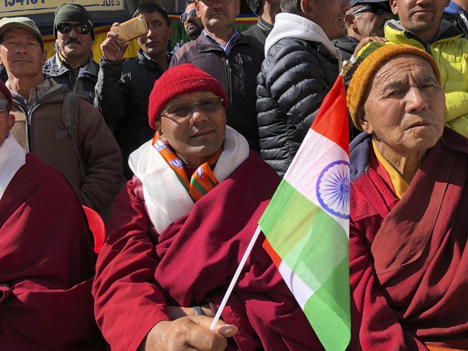 A man waves the Indian flag as people celebrate change of status of Ladakh to a Union Territory in Leh, India, Thursday, Oct. 31, 2019. India on Thursday formally implemented legislation approved by Parliament in early August that removes Indian-controlled Kashmir's semi-autonomous status and begins direct federal rule of the disputed area amid a harsh security lockdown and widespread public disenchantment. The legislation divides the former state of Jammu-Kashmir into two federally governed territories, Jammu and Kashmir and Ladakh. (AP Photo/Sheikh Saaliq)