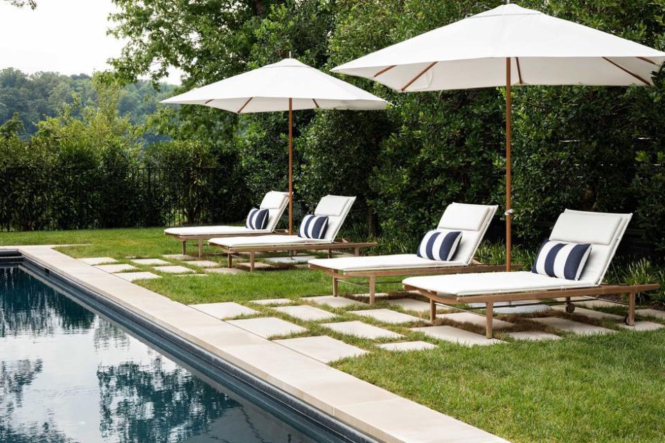 pool umbrella and lounge chairs next to pool