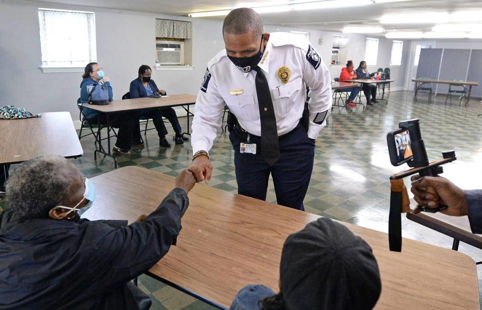 Charlotte-Mecklenburg Police Chief Johnny Jennings, center, bumps fists with an attendee at a community conversation at the Hoskins Avenue Baptist Church in Charlotte, NC on Wednesday, March 31, 2021. The community conversation was held as a result of two shootings that occurred on Tuesday afternoon that three minors were injured by gunfire including a 7-year-old girl.