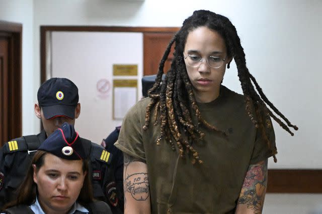 NATALIA KOLESNIKOVA/AFP via Getty Brittney Griner (R) is escorted by police before a hearing during her trial on charges of drug smuggling, in Khimki, outside Moscow on August 2, 2022