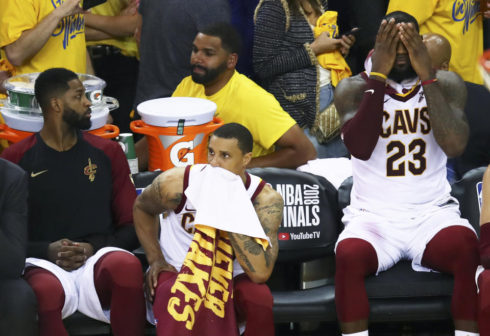 LeBron James (R) and teammates Tristan Thompson (L) and George Hill absorb their Game 2 loss to the Warriors. (AP)