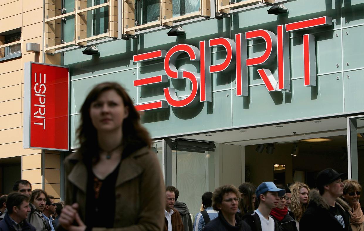 Shoppers pass an Esprit clothing store March 26, 2005 in Munich, Germany, store sign prominent in the background, female in the foreground