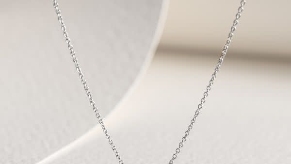 a silver chain on a white surface