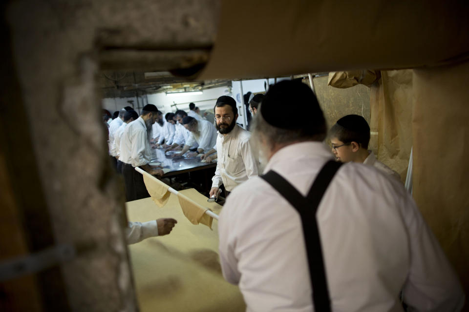 Ultra-Orthodox Jews prepare special matzoh, a traditional handmade Passover unleavened bread, at a bakery in Bnei Brak near Tel Aviv, Israel. Thursday, April 10, 2014. Jews are forbidden to eat leavened foodstuffs during the Passover holiday. Passover celebrates the biblical story of the Israelites' escape from slavery and exodus from Egypt. (AP Photo/Oded Balilty)