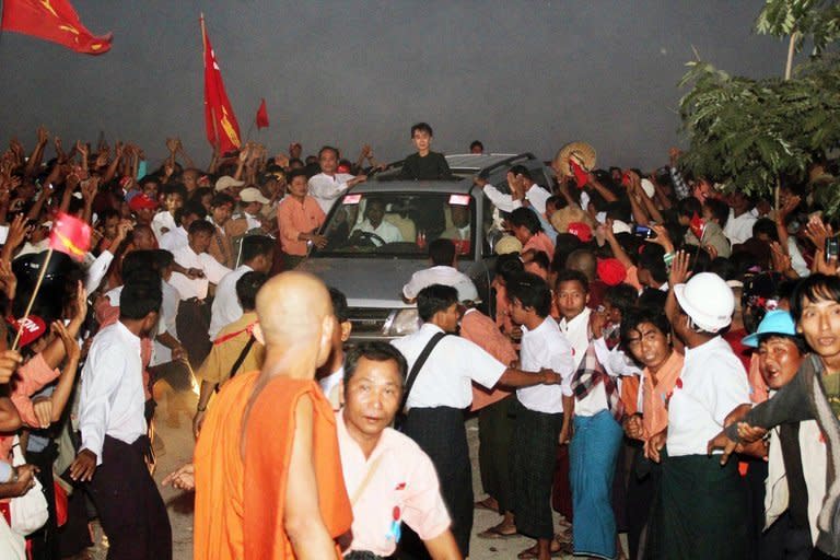 Supporters greet Myanmar democracy leader Aung San Suu Kyi near a Chinese-backed copper mine in Monywa on November 29, 2012. A report led by the opposition leader on a crackdown by police on people protesting the mine, has backed continued work at the controversial mine, despite conceding that it only brought "slight" benefits to the country