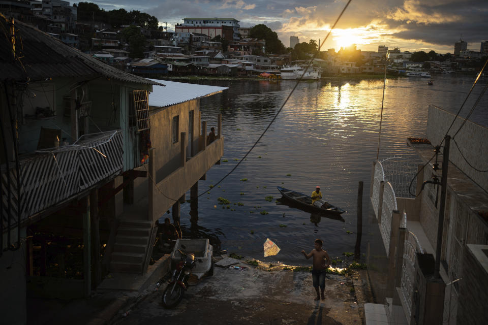 Un niño vuela una cometa en la orilla del río, en Manaos, Brasil, el 24 de mayo de 2020. Per cápita, Manaos es la ciudad de Brasil más golpeada por el COVID-19. (AP Foto/Felipe Dana)