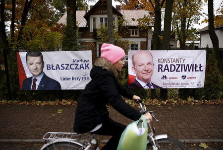 A child cycles in front of the election posters of Law and Justice candidates Mariusz Blaszczak (L) and Konstanty Radziwill (R) in Milanowek, outskirts of Warsaw, Poland October 23, 2015. REUTERS/Kacper Pempel