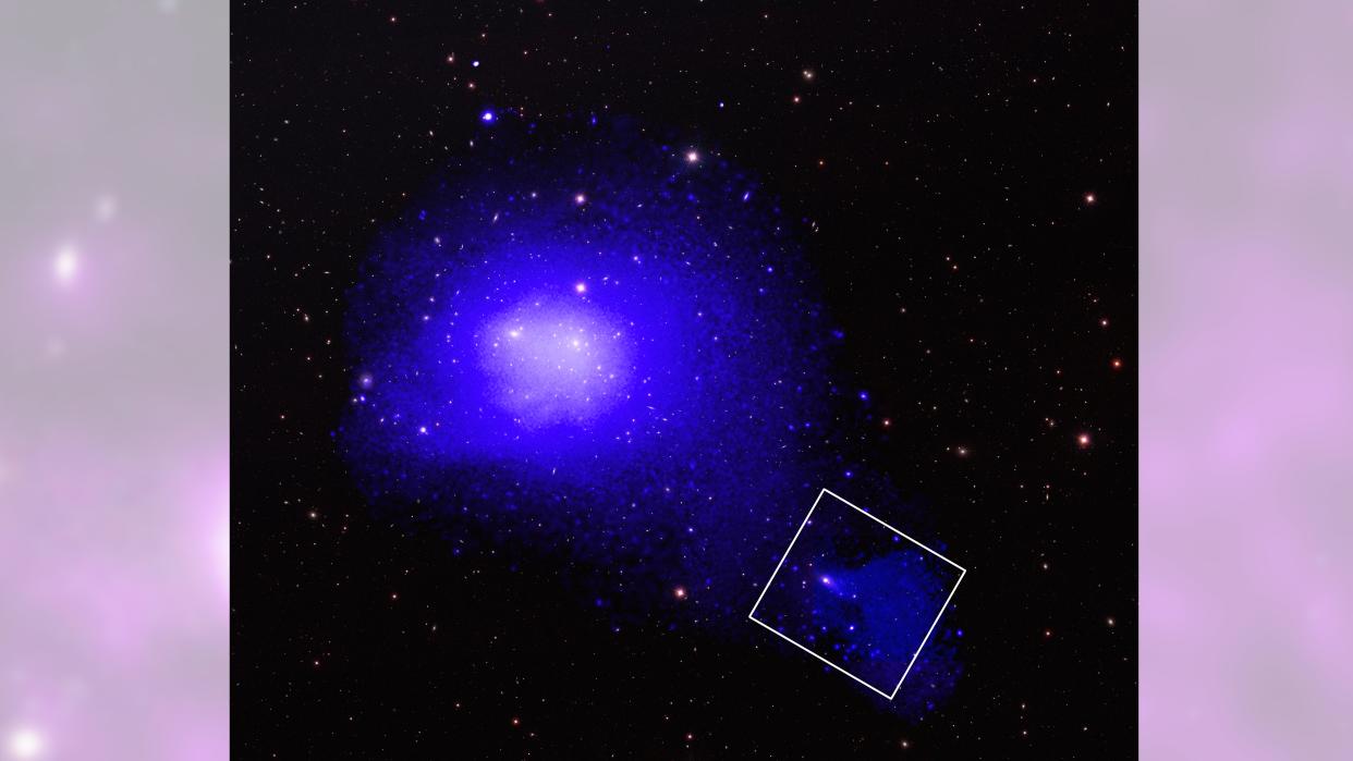  A gassy blue ball of a galaxy with a long, cloudy tail trailing behind it to the bottom right  