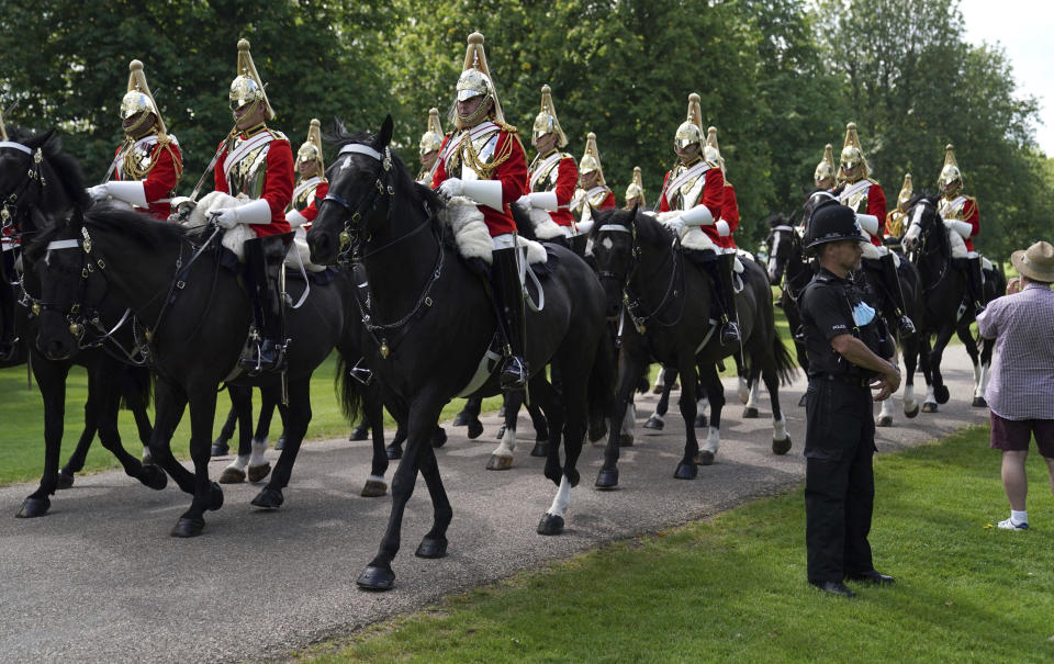 Members of the Household Cavalry make their way along the Long Walk towards Windsor Castle, Windsor, England, Saturday June 12, 2021, ahead of a ceremony to mark the official birthday of Queen Elizabeth II. (Andrew Matthews/PA via AP)
