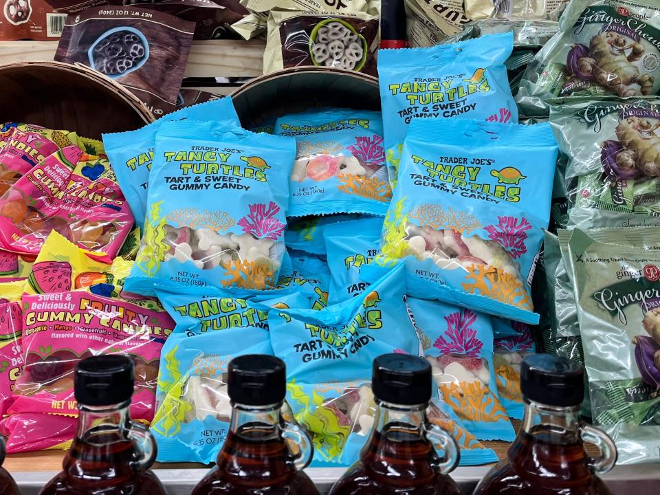 Pink and yellow, blue, green, and beige bags of candy on display at Trader Joe's