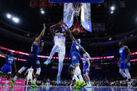 Philadelphia 76ers' Joel Embiid, center, cannot get a shot past Minnesota Timberwolves' Jarred Vanderbilt, right, and Karl-Anthony Towns during the first half of an NBA basketball game, Saturday, Nov. 27, 2021, in Philadelphia. (AP Photo/Matt Slocum)