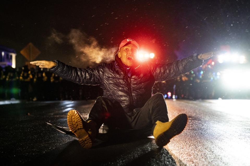 A demonstrator faces off with police outside the Brooklyn Center Police Department