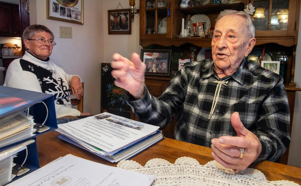 Quentin Stambaugh, surrounded by letters he wrote back to his family during World War II, talks about some of his 39 combat missions on February 8, 2024 while Tara Wenzel, left, who has been compiling the letters, looks on.