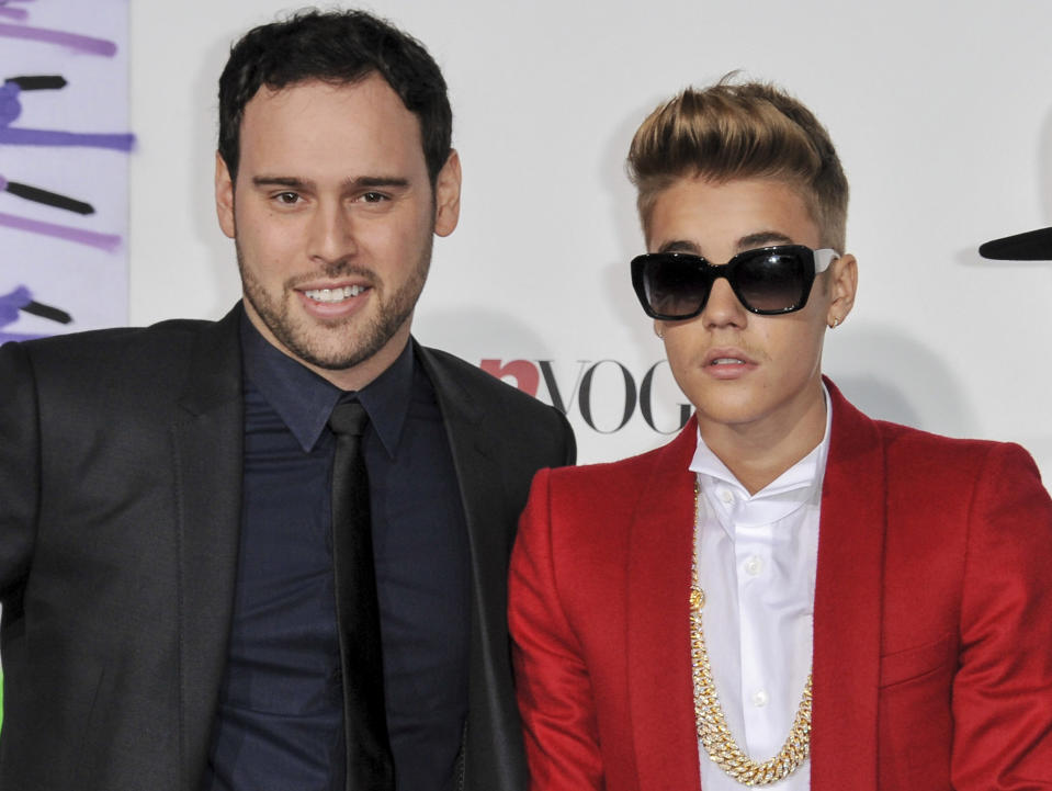 FILE - Music executive Scooter Braun, left, appears with Justin Bieber at the World Premiere of "Justin Bieber's Believe" in Los Angeles on Dec. 18, 2013. Braun is one of the most recognizable names in the music business for his work as an executive, entrepreneur, and artist manager. Publicly, he's best known for two things: discovering Justin Bieber and purchasing the master recordings to Taylor Swift's first six album, inspiring her to re-record them in an ongoing series called “Taylor's Version.” (Photo by Richard Shotwell/Invision/AP, File)