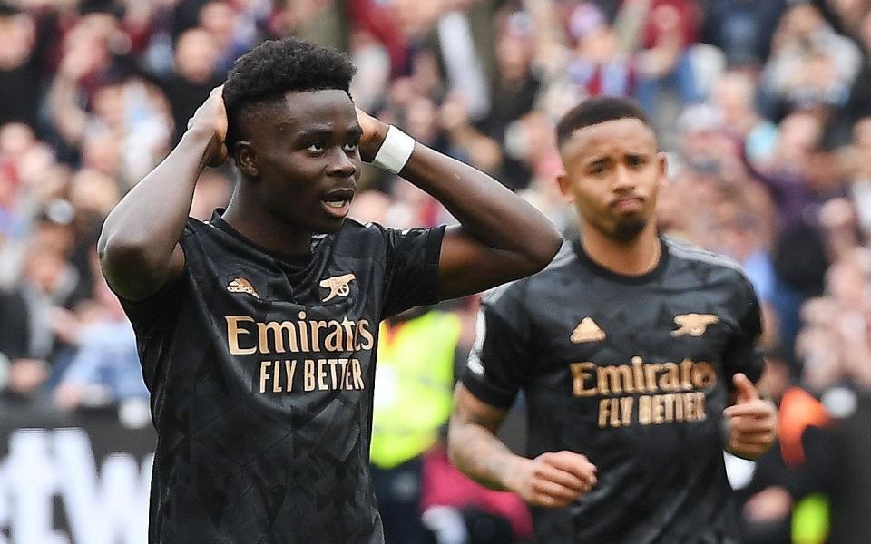 Arsenal's Bukayo Saka reacts after missing a chance to score from the penalty spot during the English Premier League soccer match between West Ham United and Arsenal London in London - Shutterstock/Andy Rain