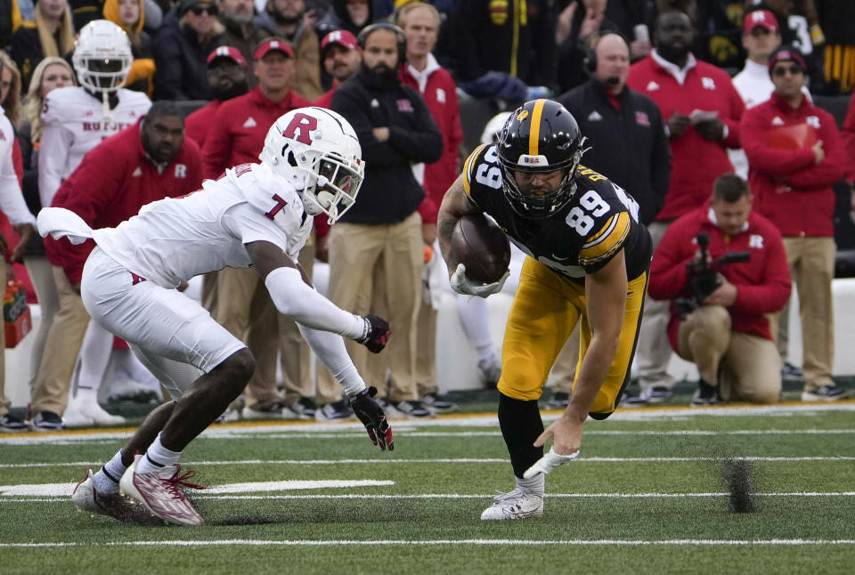 Iowa wide receiver Nico Ragaini (89) catches the ball as Rutgers cornerback Robert Longerbeam (7) closes in for a tackle during the first half of an NCAA college football game, Saturday, Nov. 11, 2023, in Iowa City, Iowa. (AP Photo/Bryon Houlgrave)