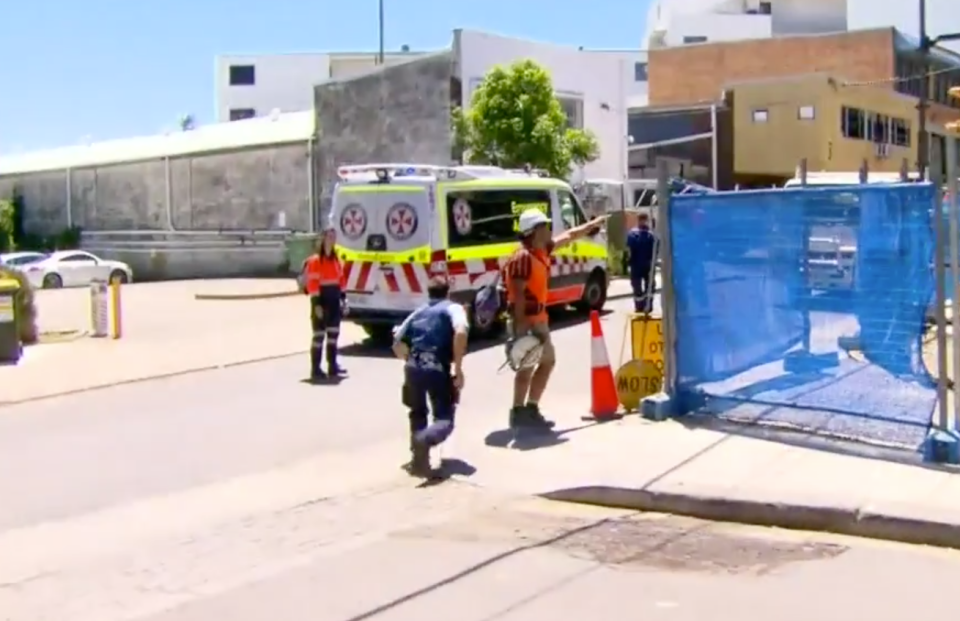 A police officer rushes to the scene of a stabbing at a construction site in St Peters. Source: Nine News