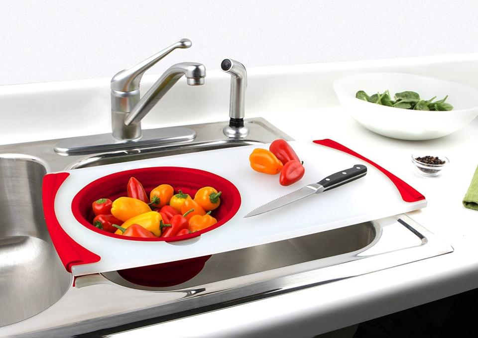 A white and red cutting board with a strainer built into it