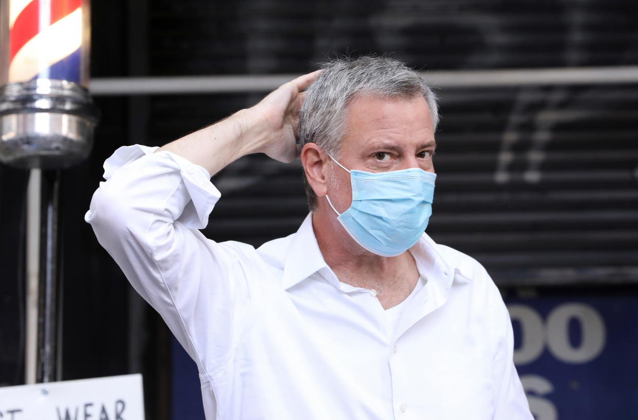 New York City Mayor Bill de Blasio jokingly smooths his new haircut at Astor Place Hairstyles during the phase two re-opening of businesses following the outbreak of the coronavirus disease (COVID-19) in New York City, New York, U.S., June 23, 2020. REUTERS/Caitlin Ochs