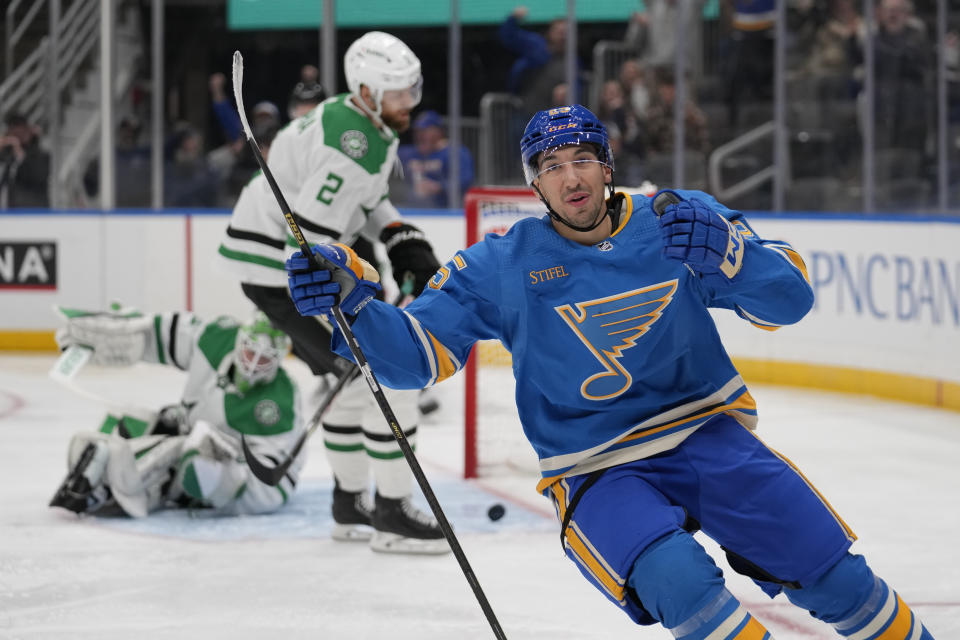 St. Louis Blues' Jordan Kyrou, right, celebrates after scoring past Dallas Stars goaltender Scott Wedgewood and defenseman Jani Hakanpaa (2) during the second period of an NHL hockey game Saturday, Dec. 16, 2023, in St. Louis. (AP Photo/Jeff Roberson)