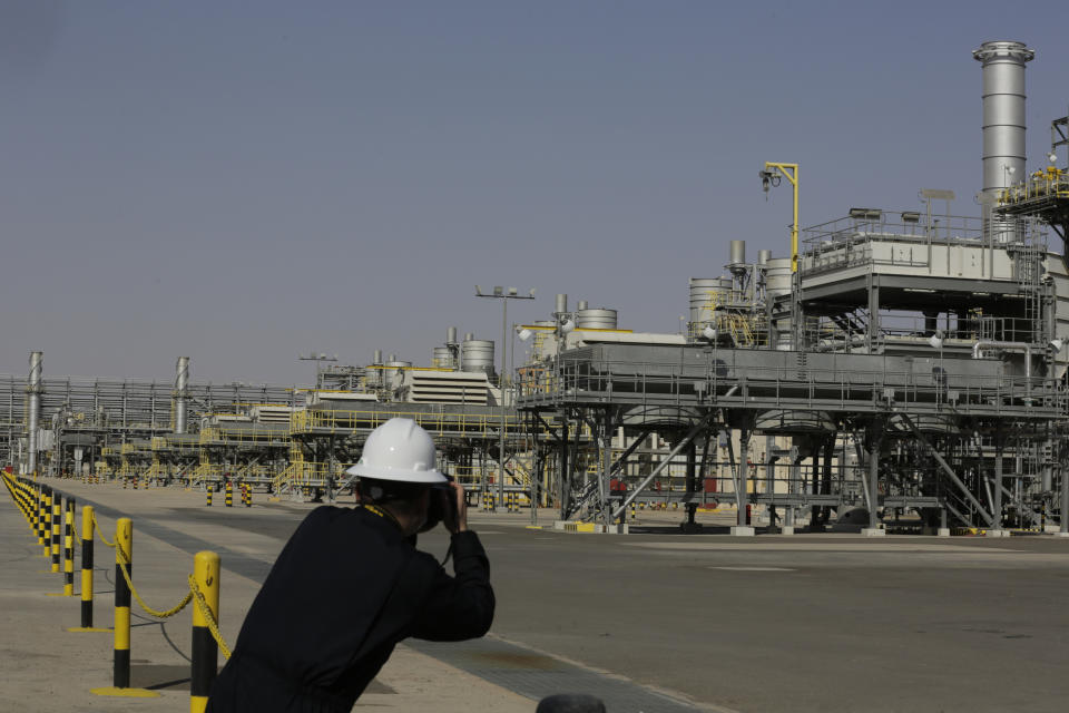 FILE - A photographer takes pictures of the Khurais oil field during a tour for journalists, 150 km east-northeast of Riyadh, Saudi Arabia, June 28, 2021. A cut in oil production is on the table when OPEC oil-producing countries meet Wednesday. The OPEC+ alliance that includes Saudi Arabia and Russia is weighing a cut of a million barrels per day or more. The idea is to boost oil prices that have fallen from summer highs of over $100 to around $80 for U.S. crude. (AP Photo/Amr Nabil, File)