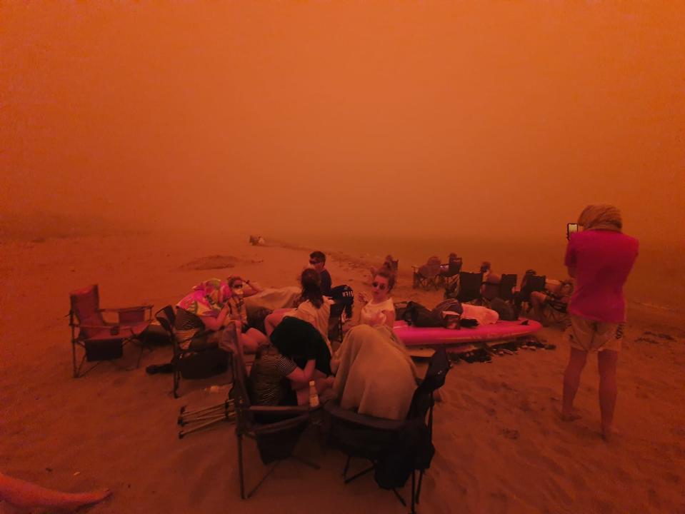 This photo shared online shows people evacuating to the beach in Batemans Bay. Source: Twitter/Alastair Prior 