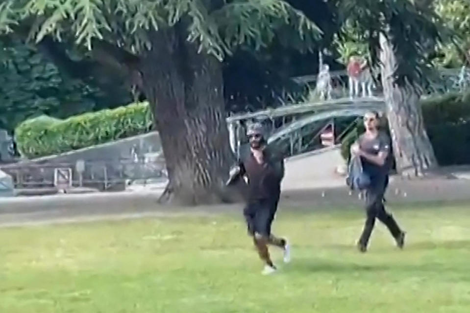 A screengrab taken from a video obtained by AFPTV on June 8, 2023 shows a man armed with a knife running away after an attack on a group of pre-school children playing by a lake in the French Alps city of Annecy, wounding four children and at least one adult and sending shockwaves through the country. / Credit: AFPTV/AFP via Getty